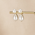 Pearl Duo Drop Earrings, pair of earrings with round pearl studs and teardrop pearls hanging below, on a gold bar